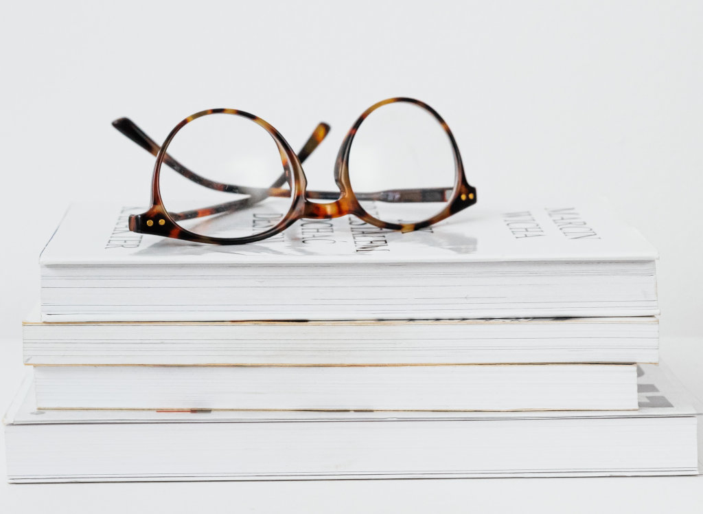 Livros sobre postos e oculos de leitura sobre eles.